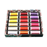 Die ACKERMANN® EMBROIDERY Box enthält 36 Spulen Stickgarn (je 260 m, Stärke 40) in den Farben Gelb, Rot, Lila, Pink, Orange und Weiß, stilvoll arrangiert vor einem dekorativen Box-Hintergrund.