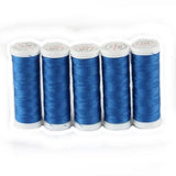 Fünf Spulen ACKERMANN® Universal-Nähgarn Stärke 120 (5 × 200 m, Farbe 7275 blau) sind vertikal in einer Reihe vor einem weißen Hintergrund aufgereiht.