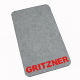 Eine rechteckige, graue Filzunterlage mit abgerundeten Ecken, auf der in der rechten unteren Ecke der Schriftzug „GRITZNER“ in fetten roten Buchstaben zu sehen ist. Diese ACKERMANN® GRITZNER Unterlage Matte eignet sich für jede Nähmaschine – einschließlich Overlock- und Coverlock-Maschinen – und ist somit ein praktisches Ersatzteil für Ihre Nähausrüstung.