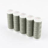 Fünf Spulen ACKERMANN® Universal-Nähgarn Stärke 120 mit jeweils 200 Metern Garn in der Farbe 0791 Graugrün sind auf weißem Hintergrund in einer Reihe angeordnet. Jede Spule ist mit einer weißen Kappe versehen, auf der roter und grüner Text zu sehen ist, der auf das hochwertige Polyester-Material dieses strapazierfähigen Nähgarns von ACKERMANN® hinweist.
