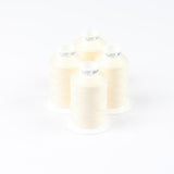 Vier Spulen ACKERMANN® Ackermann Bauschgarn Nähgarn Stärke 120 (Farbe 5209 beige) mit jeweils 1.000 Metern Garn sind dicht nebeneinander auf einem weißen Hintergrund angeordnet. Jede zylindrische Spule hat eine weiße Kappe mit aufgedrucktem Text.